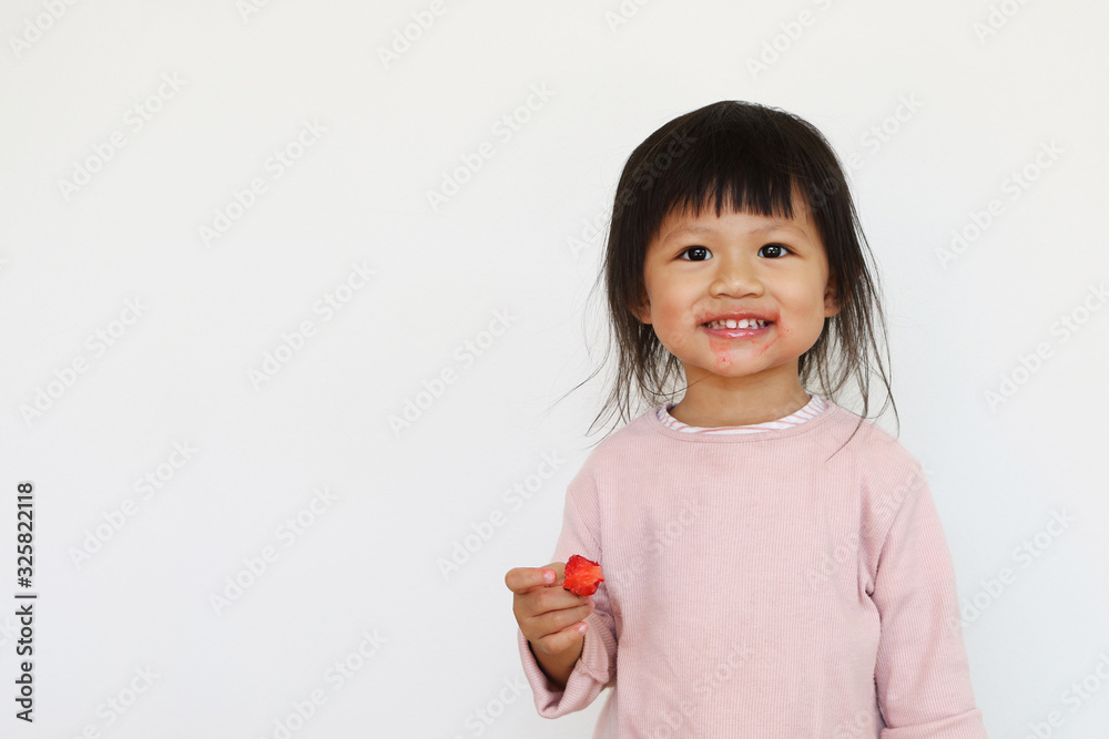smiling asian girl enjoys eating red strawberry and having dirty face smiling asian girl enjoys eating red strawberry and having dirty face