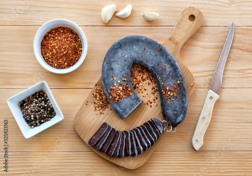 Cut Slices of Special Pirot horseshoe ironed sausage - Peglana Pirotska kobasica, made from veal, sheep and goat meat, with addition of garlic, mixed pepper, Crushed dried chili peppers and spices, on photo