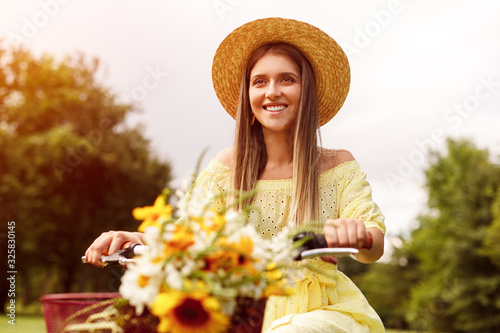 Happy female riding bicycle with flowers