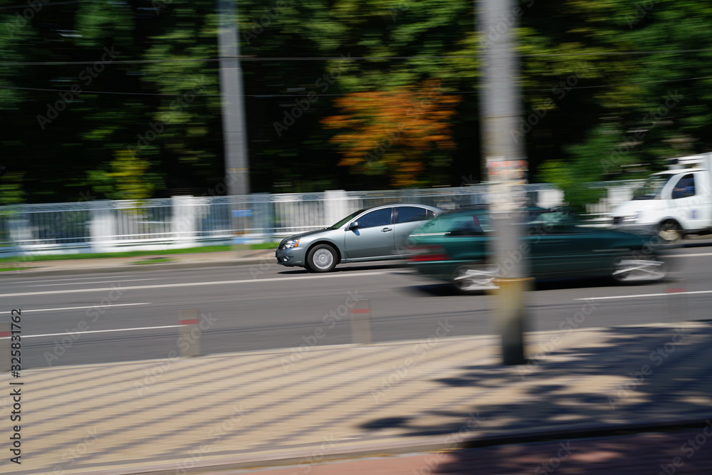 Modern cars motion at the city street on sunny day,  Kiev, Ukraine. City traffic.