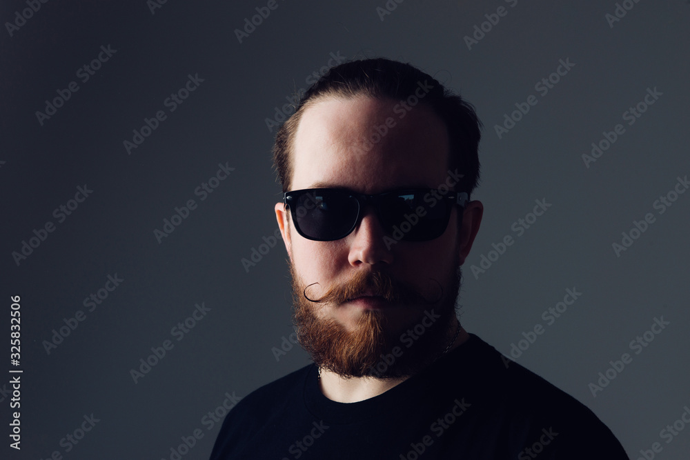 Handsome young man with a beard and mustache in sunglasses in fashionable clothes. Handsome young man with a beard and mustache in sunglasses in fashionable clothes.
