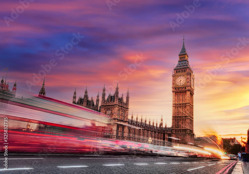 Big Ben with red bus against colorful sunset in London  England  UK