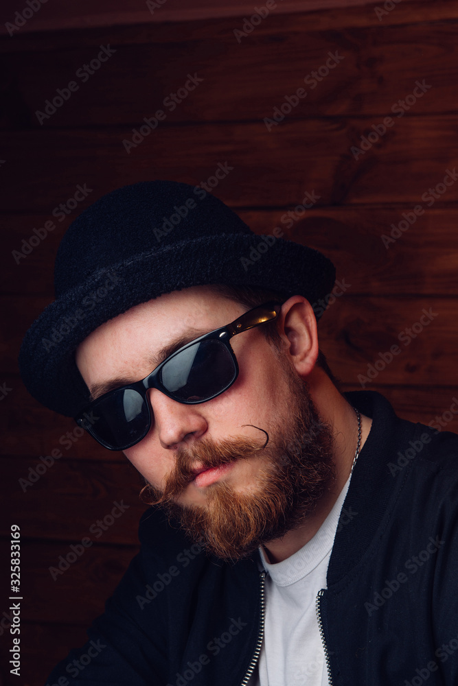 Handsome young man with a beard and mustache in sunglasses in fashionable clothes. Handsome young man with a beard and mustache in sunglasses in fashionable clothes.