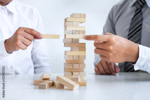 Planning Risk and Strategy in Business, Image of two Businessman hand placing making wooden block structure growing up the tower and protection to planning and development to successful