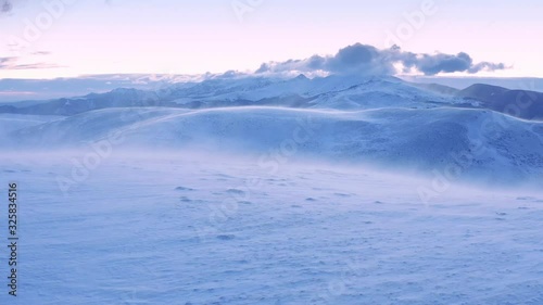 Aerial Flight Over Wind Blowing Winter Mountain Hills At Sunset Sunrise Beautiful Colors Sky Cold Weather Cinematic Flight 4k photo