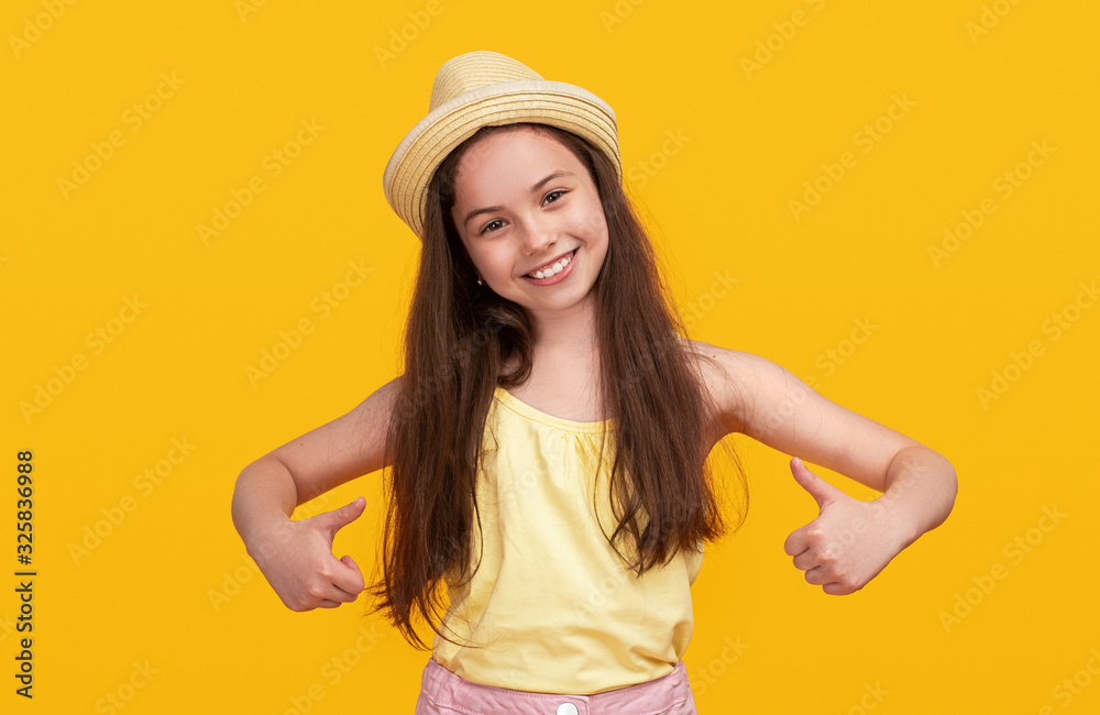 Joyful girl showing thumbs up on yellow background Joyful girl showing thumbs up on yellow background