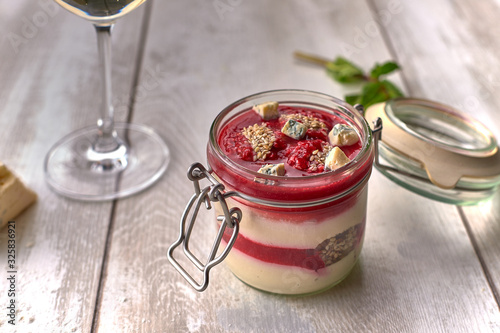 Raspberry - cheese panakota, with a glass of white wine, cheese, mint, on a white board photo