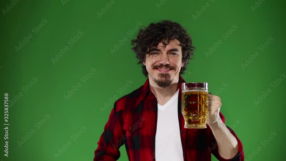 Saint Patrick Day. Young Oktoberfest man serving big beer mug with drink isolated on yellow background. Slow Motion. Chroma key. Saint Patrick Day. Young Oktoberfest man serving big beer mug with drink isolated on yellow background. Slow Motion. Chroma key.