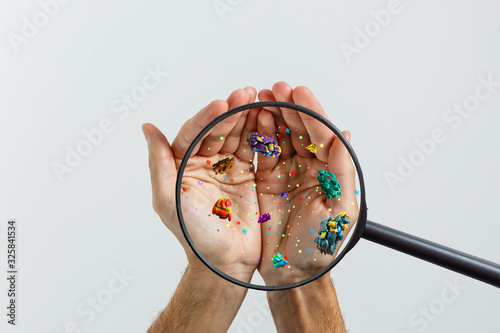 Photos Close up on a sick man hand through magnifying glass transmitting virus by skin