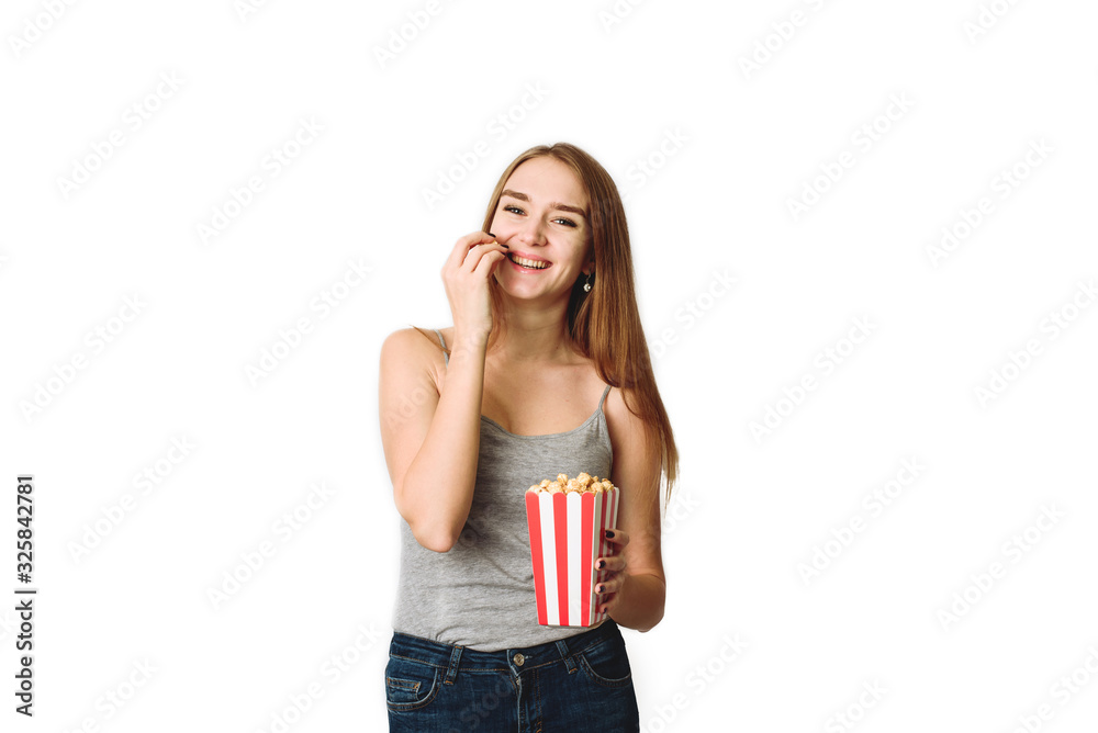 girl fooling around with popcorn in the studio. Portrait of a laughing girl holding popcorn box and looking at camera isolated over white background. Coy Space, template for blog and advertising girl fooling around with popcorn in the studio. Portrait of a laughing girl holding popcorn box and looking at camera isolated over white background. Coy Space, template for blog and advertising