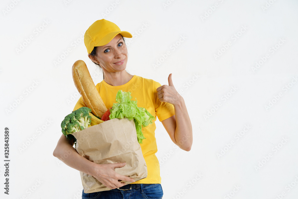 Delivery woman in yellow holding grocery bag and giving thumbs up, on white background Delivery woman in yellow holding grocery bag and giving thumbs up, on white background