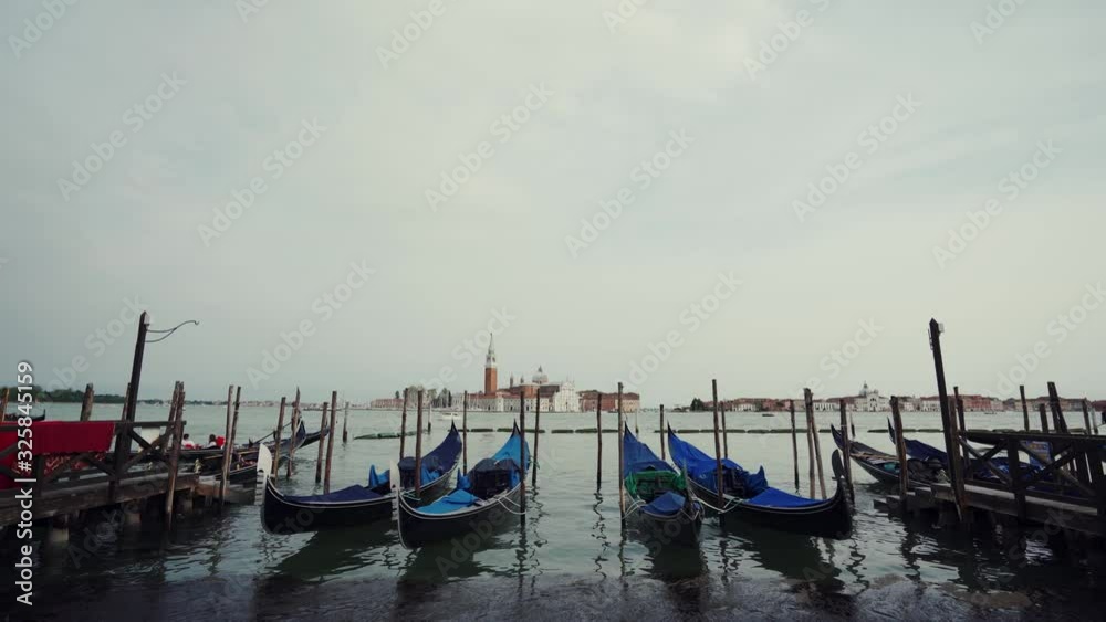 Gondolas moored by Saint Mark square with San Giorgio Maggiore church in Venice Gondolas moored by Saint Mark square with San Giorgio Maggiore church in Venice