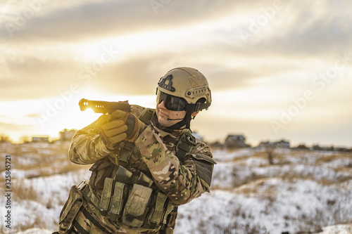 An angry desperate professional Ukrainian soldier shoots a pistol in a winter field near Kharkov. Ukrainian Russian conflict.
