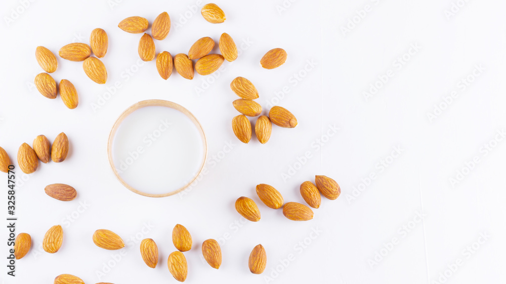 Obraz premium Almond milk with almond on white background. Homemade organic almond milk in a paper cup for healthy breakfast. Vegan milk from almonds nuts in kraft paper cup. Alternative milk. Zero waste