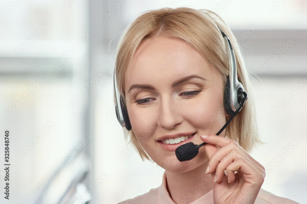 Smiling agent blond woman with headsets. Portrait of mature support phone operator in headset at workplace. Smiling agent blond woman with headsets. Portrait of mature support phone operator in headset at workplace.