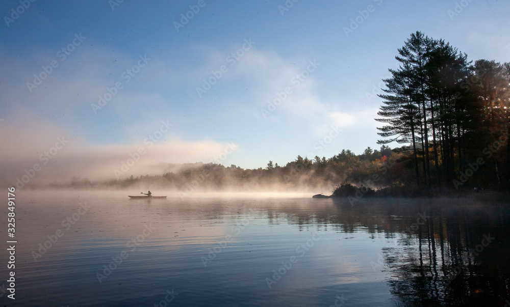 Solo paddling on a misty pond at sunrise. Solo paddling on a misty pond at sunrise.