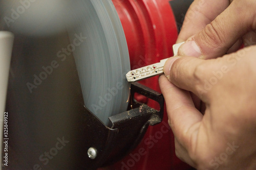 Closed image of duplicate key in the process of sanding by the locksmith to eliminate burrs