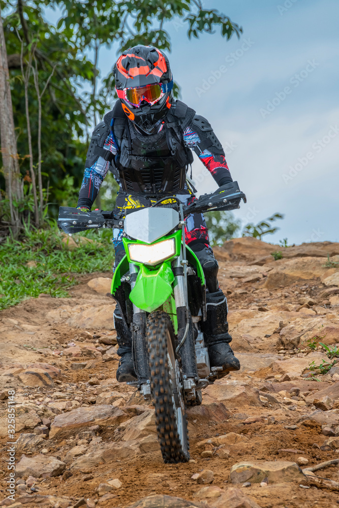 Woman on off road bike descending a hill on a rough trail Woman on off road bike descending a hill on a rough trail