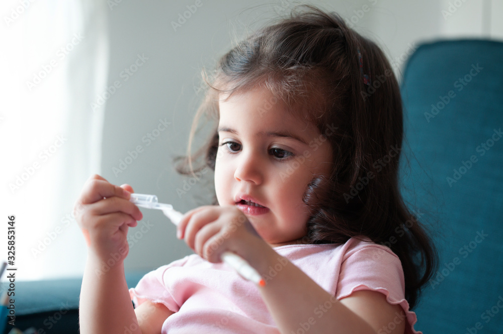 Adorable little baby girl is playing with pencil at home,sitting in a living room,happy childhood and domestic life concept Adorable little baby girl is playing with pencil at home,sitting in a living room,happy childhood and domestic life concept