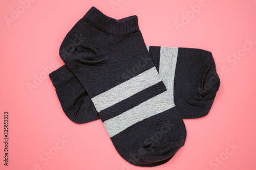 Dark blue sports socks top view. Black short pair socks on a pink background. Women's cotton socks for sports.