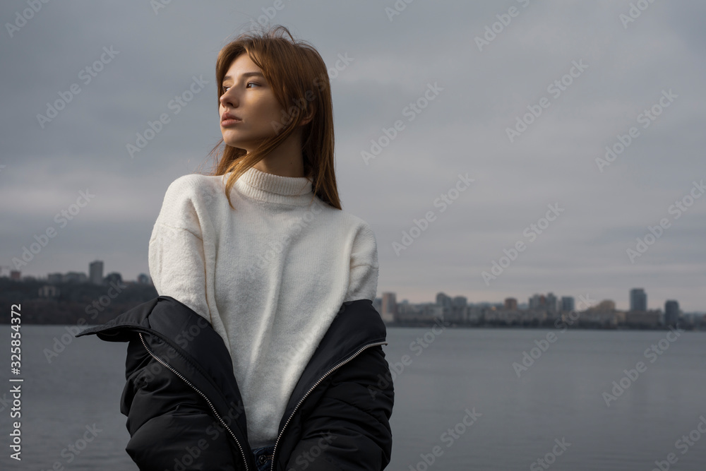 Portrait of woman in winter wear against city background