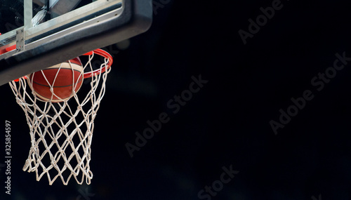 Fotografija The orange basketball ball flies through the basket