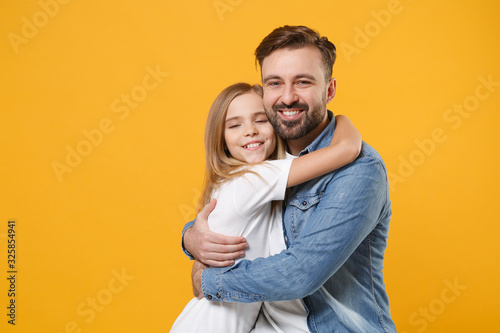 Smiling bearded man in casual clothes hugging with cute child baby girl. Father, little kid daughter isolated on yellow orange background studio portrait. Love family day parenthood childhood concept.