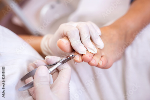 Pedicure salon employee using nail nippers