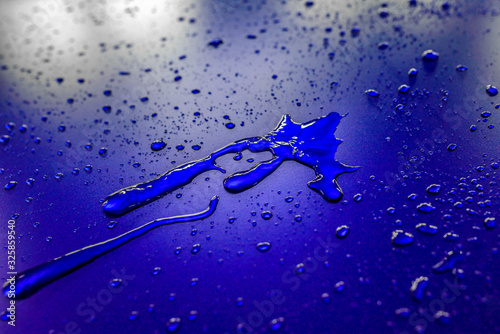 Water droplets on waterproof surface of the car vinyl film are blue purple. Texture