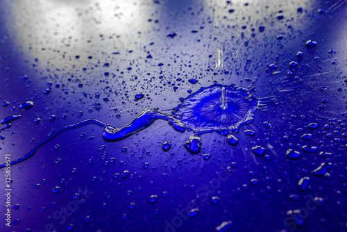 Water droplets on waterproof surface of the car vinyl film are blue purple. Texture