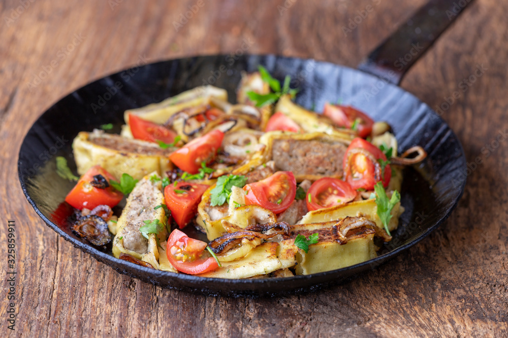 swabian maultasche with onions in an iron pan