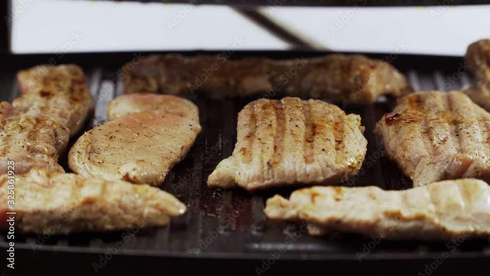 Preparation of fried meat. cook closes the electric grill. Steaks pork and beef. Close-up Preparation of fried meat. cook closes the electric grill. Steaks pork and beef. Close-up
