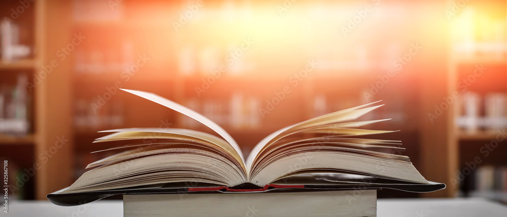 Stack of books in the library and blur bookshelf background Stack of books in the library and blur bookshelf background