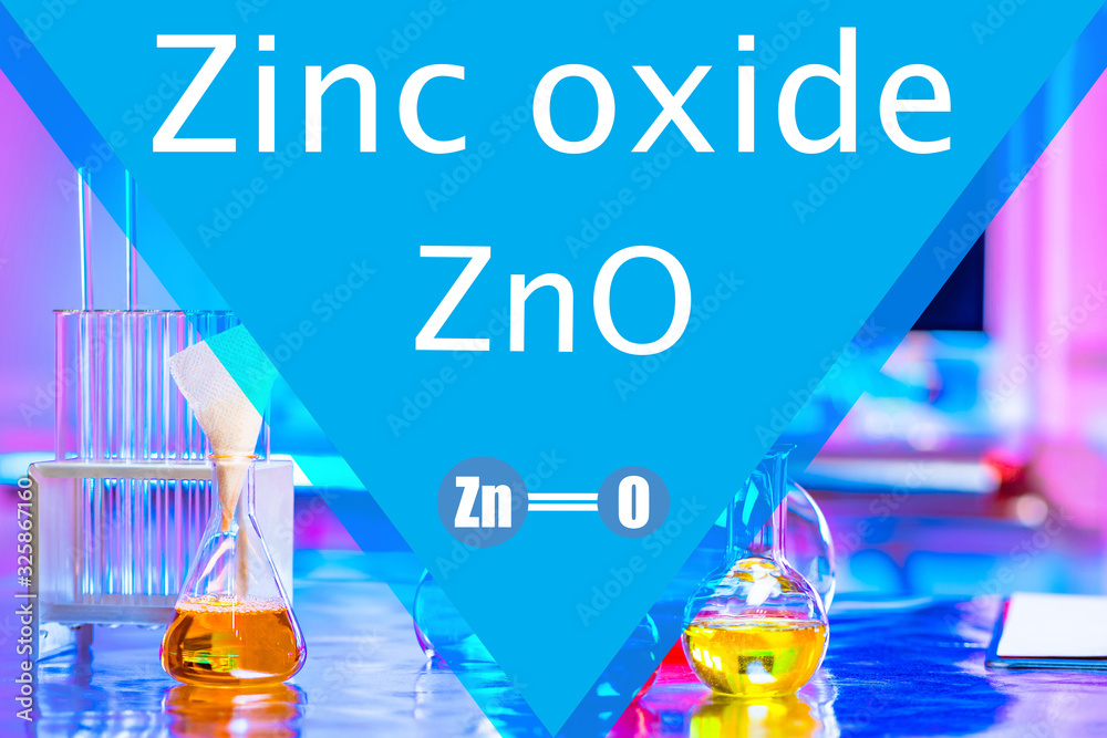 Zinc oxide. ZnO on a blue background. Glass test tubes in the