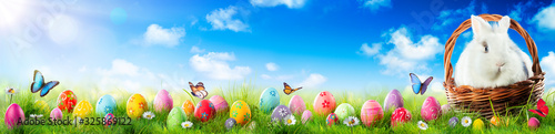 Easter Eggs And Adorable Bunny In Basket On Grass