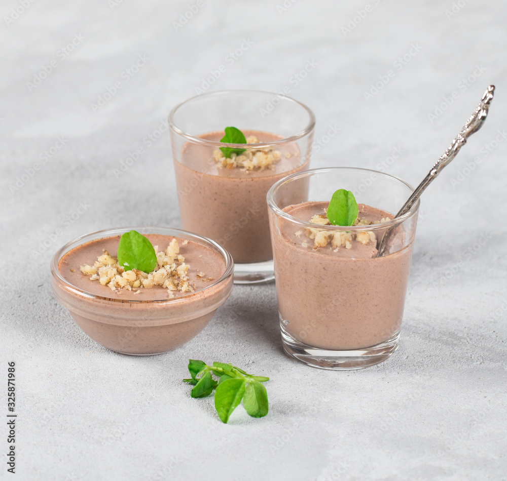 Chocolate nut jelly in a glass on a light background Chocolate nut jelly in a glass on a light background