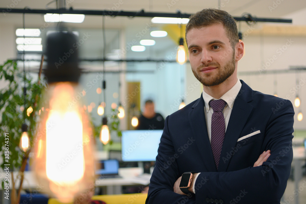 Happy successful business leader posing while his team in background. Happy successful business leader posing while his team in background.