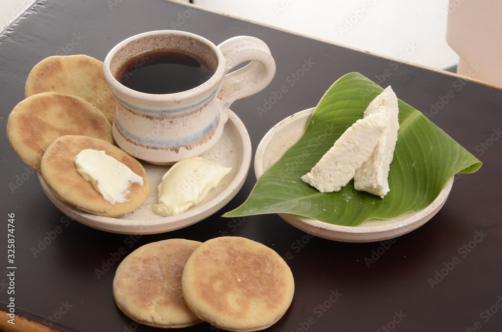 Fototapeta premium arepa de trigo venezolana con queso cuajado y taza de café caliente