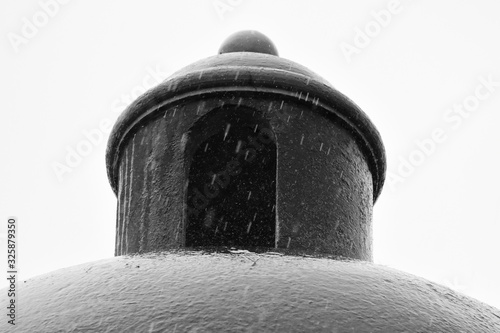 Gotas de lluvia cayendo sobre una cúpula de una casa con un contraste medio en blanco y negro photo
