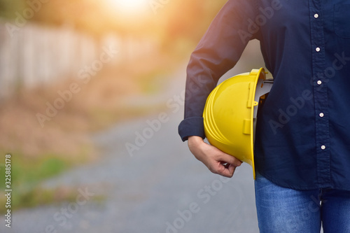 Woman Engineer holding hard hat safety