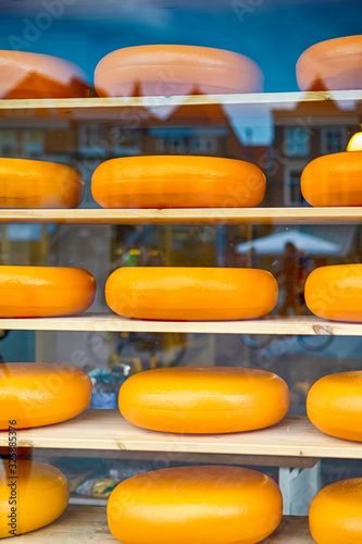 Stack of Traditional National Dutch Cheese Heads on One of The Shelves of Showcase in Old City  Delft in The Netherlands.
