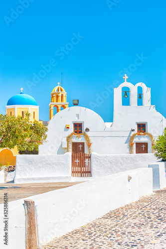 Traveling Concepts. View of Traditional Greek Churches and Houses of Oia or Ia at Santorini Island in Greece With Cross and Bells. Picture Taken at Daytime.