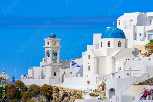 A blue domed church with bell tower in Imerovigli village, Santorini, Greece photo