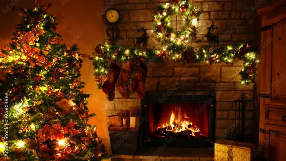 Beautiful 4k shot of firewood flame burning fireplace loop in cosy festive Christmas tree New Year decoration Noel room