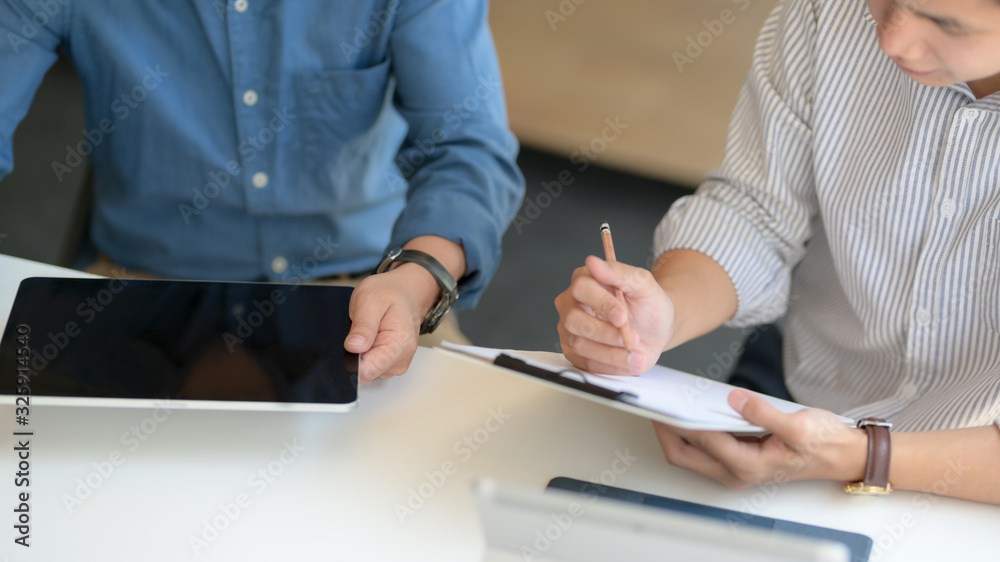 Cropped shot of two businessman consulting on their work on white desk