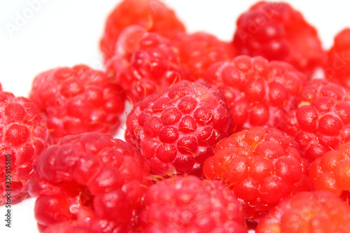 Sweet food. Summer dessert. Fresh food. Nature background. Abstract fruit background.Macro stack raspberries against, great design for any purposes. White table background