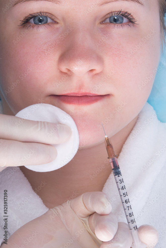 close-up, hands in sterile gloves, giving a beauty injection to a woman, in part of the chin close-up, hands in sterile gloves, giving a beauty injection to a woman, in part of the chin