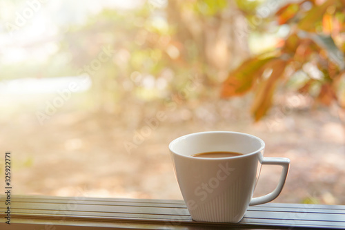 A cup of coffee by the window and sun light