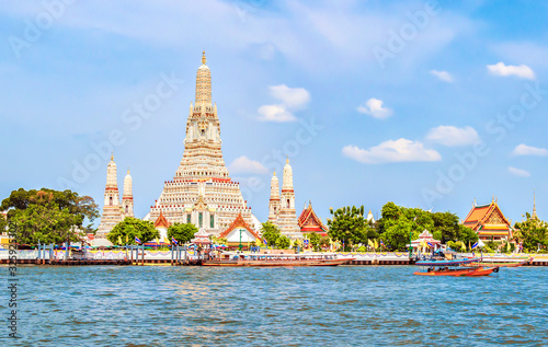 Tourist sightseeing Boat parking at pier with Grand Pagoda of Wat Arun "Temple of Dawn" Temple, Landmark of Bangkok