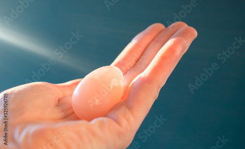 woman holding a pink quartz yoni egg